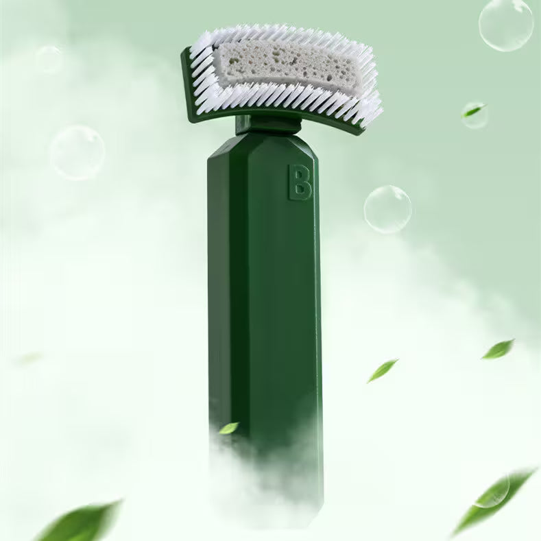 Green handheld scrubber with bristle brush head on a light green background with bubbles and leaves.
