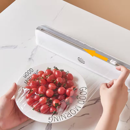 Person using a vacuum sealer to seal a plate of tomatoes on a marble surface.