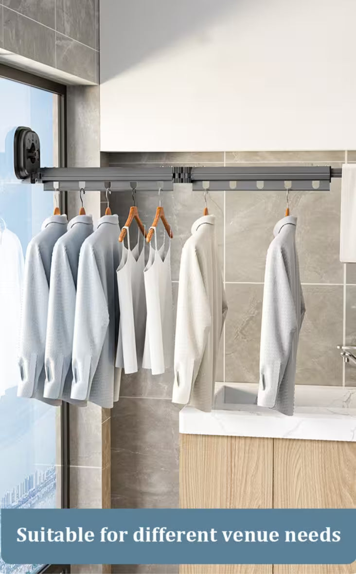 Clothing hanging on a retractable clothesline in a room with tiled walls and a window.