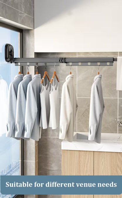Clothing hanging on a retractable clothesline in a room with tiled walls and a window.