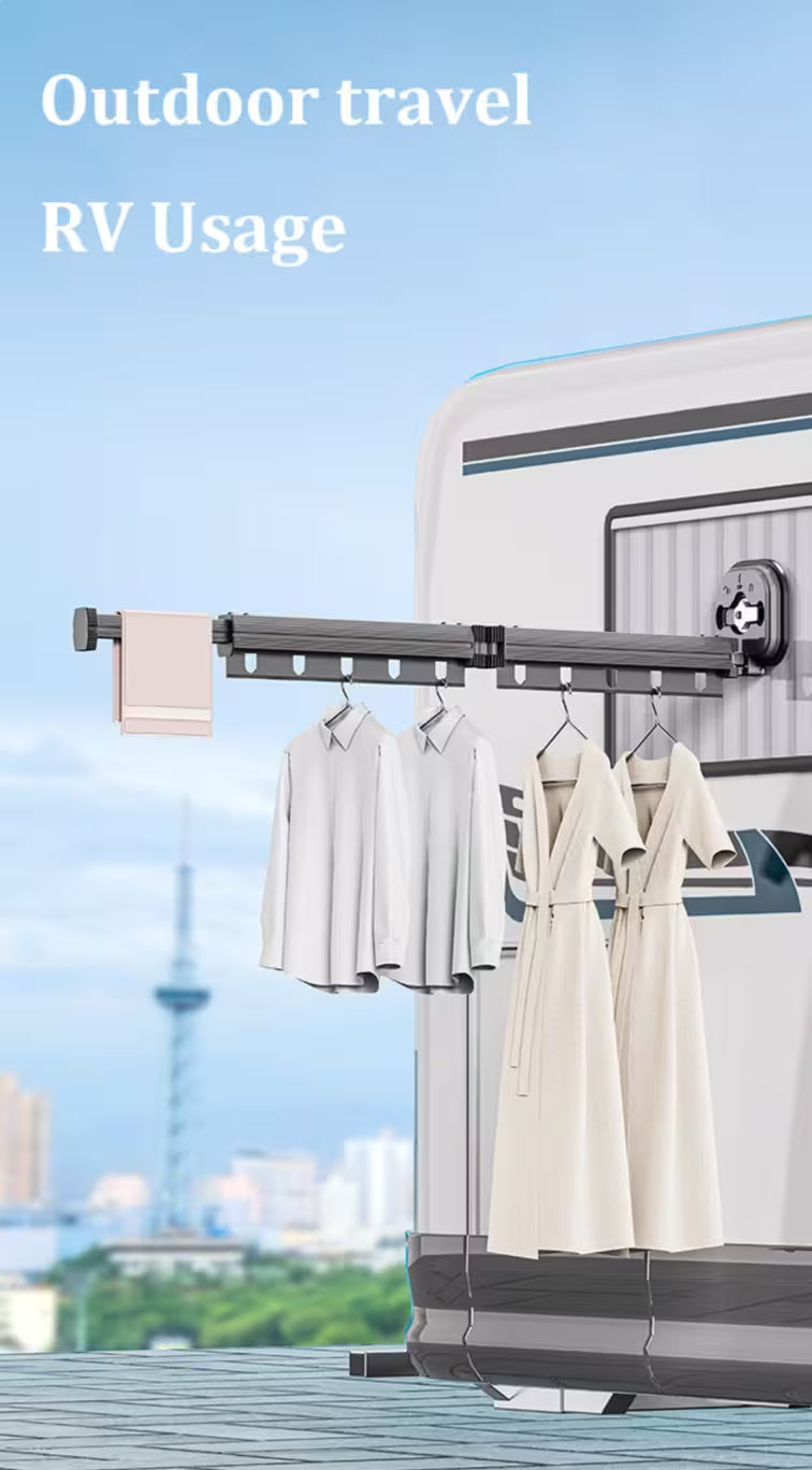 Clothes hanging on a clothesline attached to an RV with a cityscape in the background