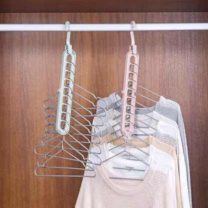 Two metal hangers with clothes on a wooden wardrobe background
