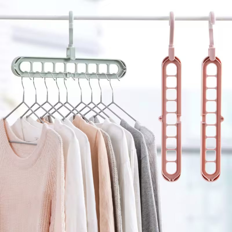 Clothing hanger with multiple hooks holding clothes, next to two additional hangers on a white background.