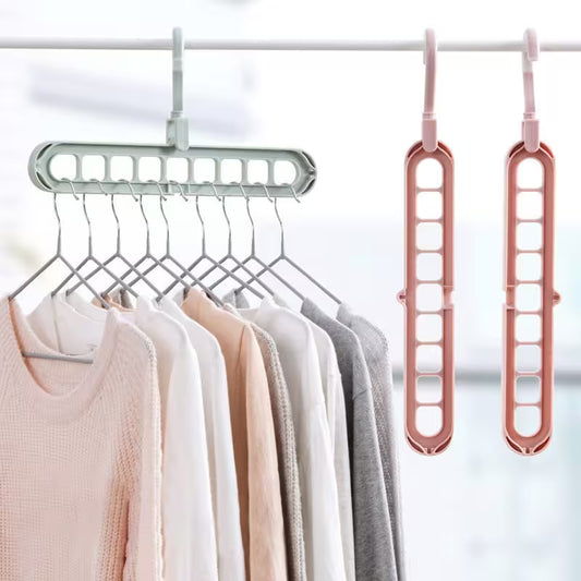 Clothing hanger with multiple hooks holding clothes, next to two additional hangers on a white background.