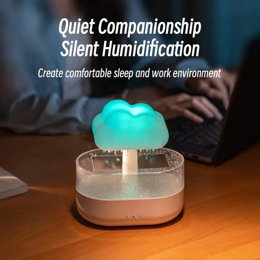 Humidifier with cloud design on a desk, person using laptop in background