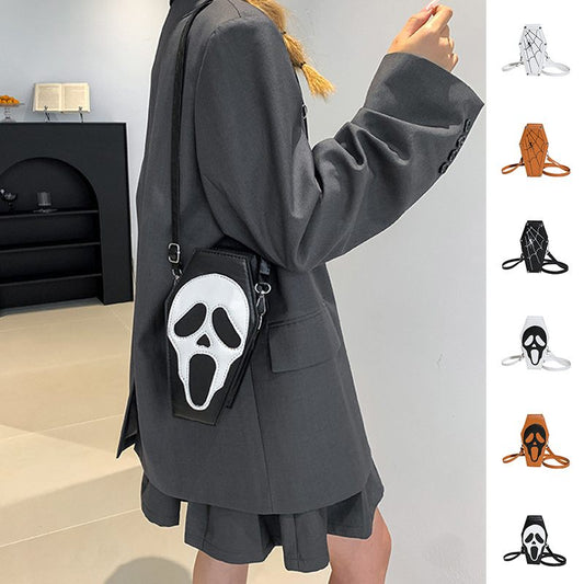 Person wearing a dark gray coat with a small bag featuring a white face design.