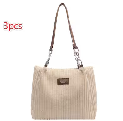 Beige handbag with brown strap on a white background