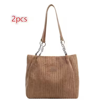 Brown handbag with chain detail on a white background
