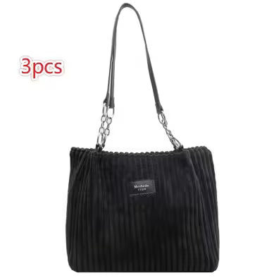 Black pleated handbag with chain detail on a white background