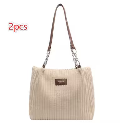 Beige handbag with brown handle on a white background