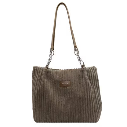 Brown ribbed handbag with a chain detail on a white background