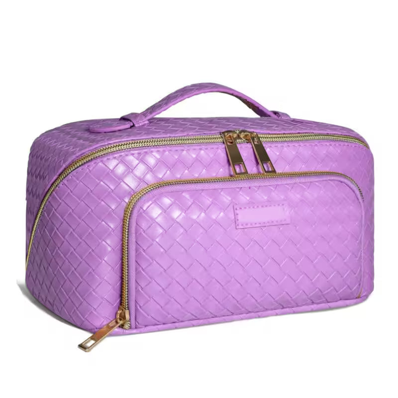 Purple quilted cosmetic bag with gold zippers on a white background