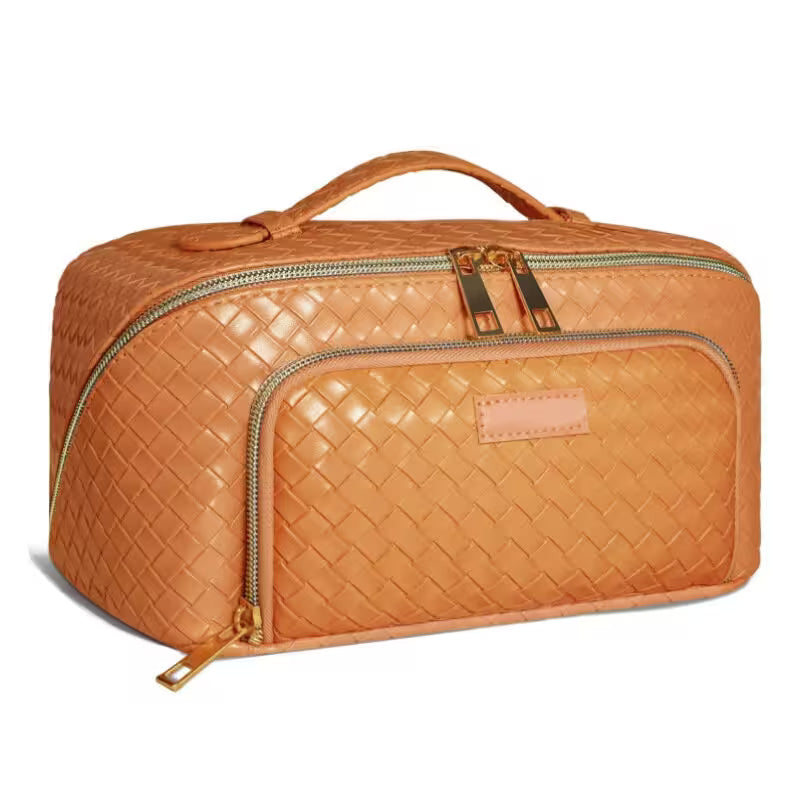 Orange woven travel bag with gold zippers on a white background
