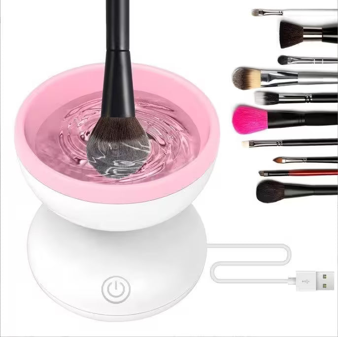 Makeup brush cleaning station with pink basin, brushes, and USB cable on a white background