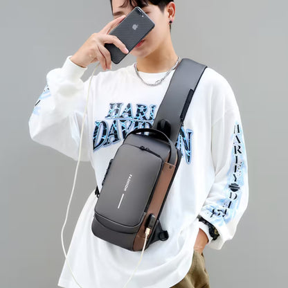 Person wearing a black crossbody bag with a gray strap, holding a smartphone.
