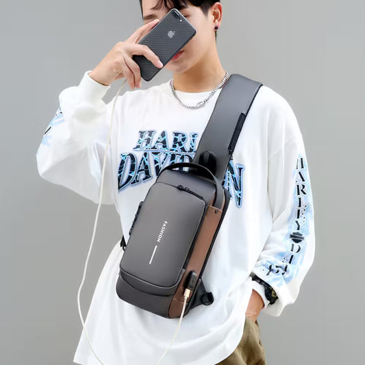 Person wearing a black crossbody bag with a gray strap, holding a smartphone.