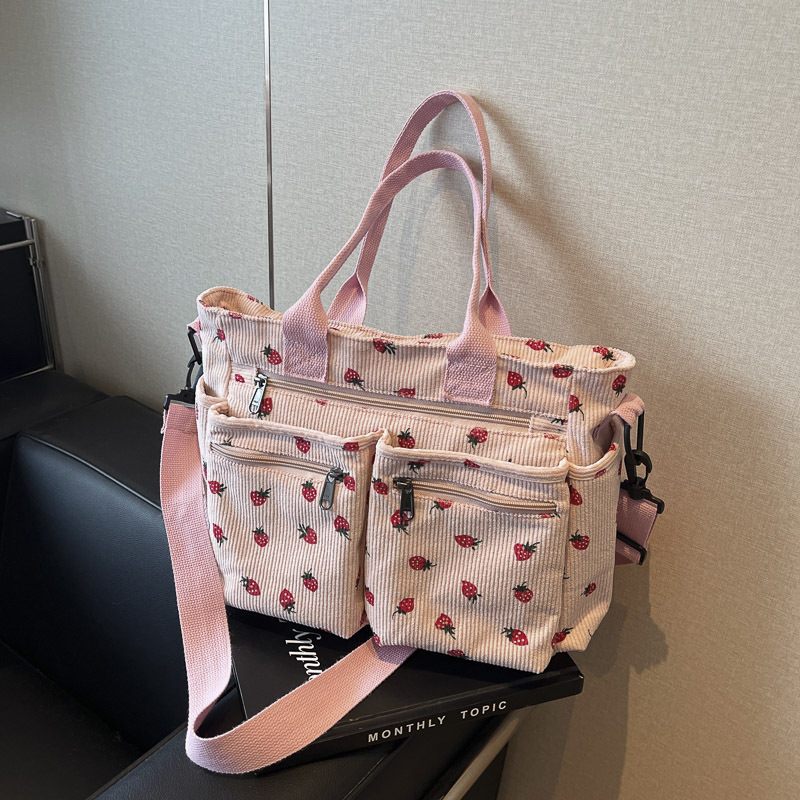 Pink floral-patterned tote bag with multiple compartments on a magazine.