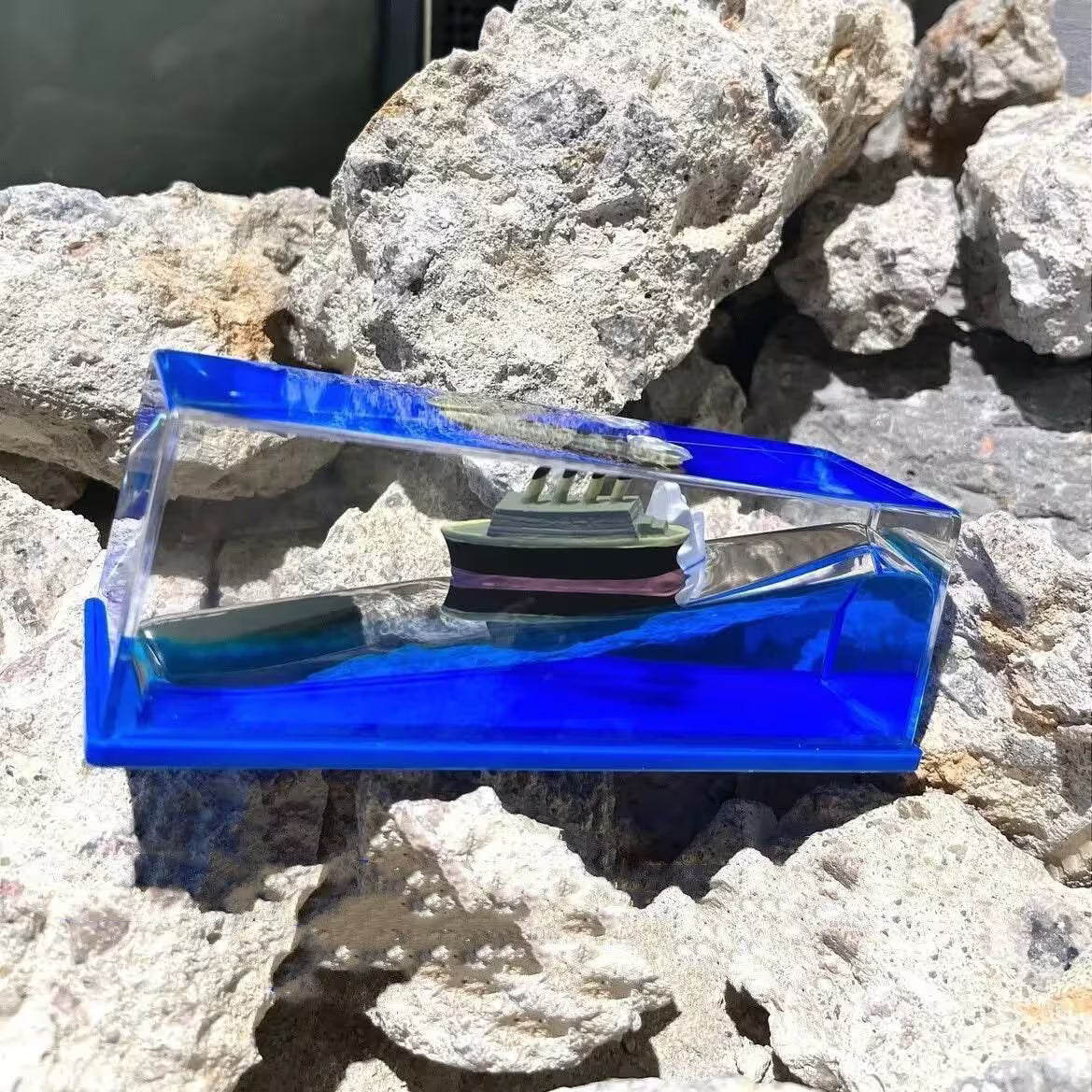Blue and clear plastic case on a rocky surface