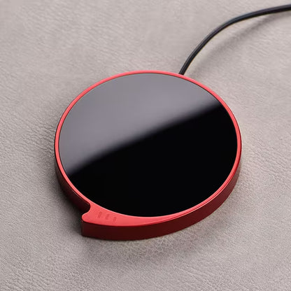 Red and black circular device on a gray surface
