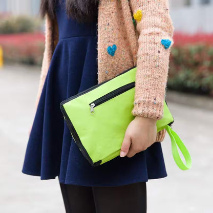 Person holding a green clutch bag with a blurred background