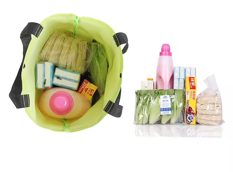 Green reusable shopping bag filled with groceries next to unpacked items on a white background