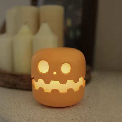 Ceramic jack-o'-lantern with glowing face on a neutral background