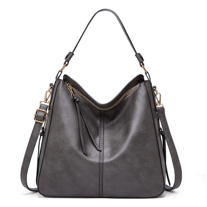 Gray shoulder bag with gold accents on a white background