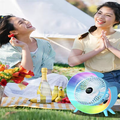 Two women enjoying a picnic with a colorful fan on a grassy area.