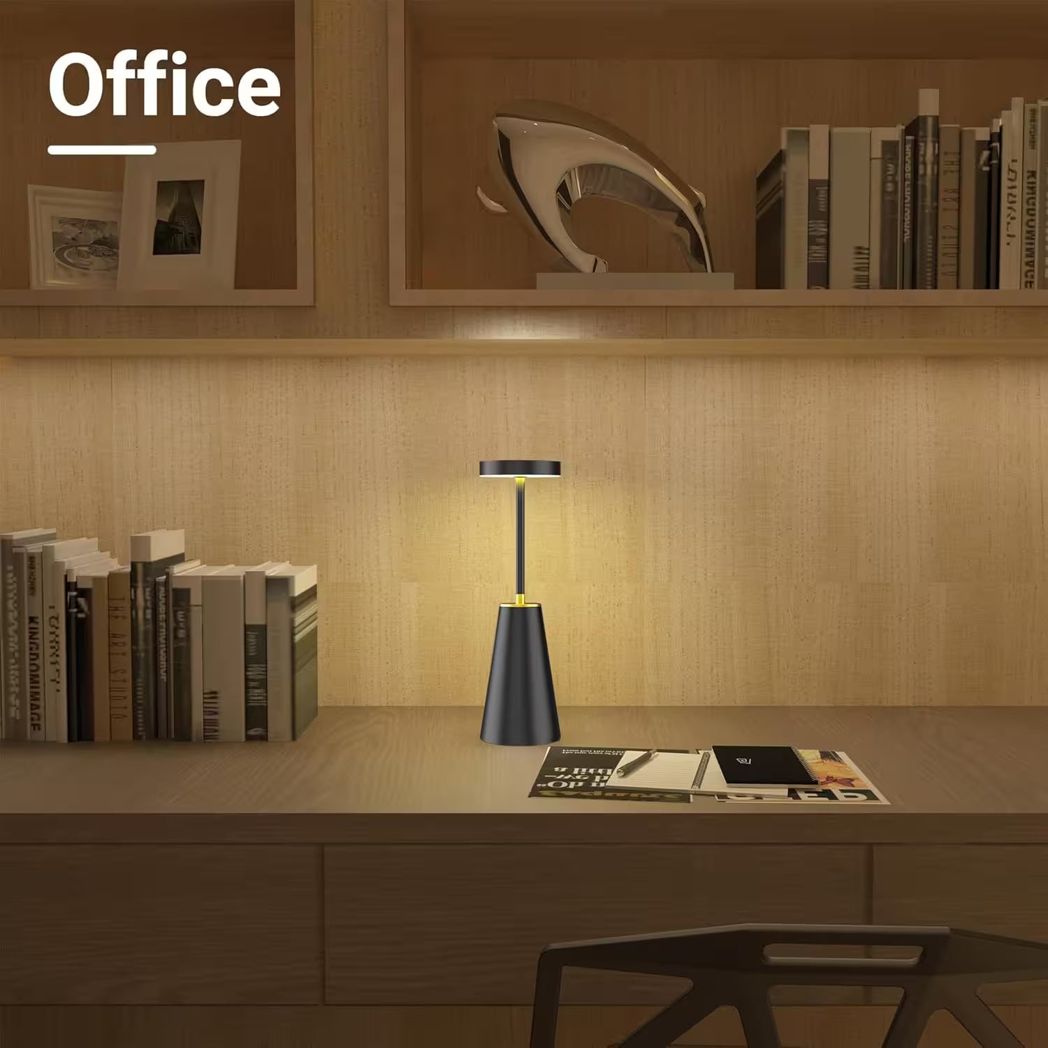Desk with a lamp and books in an office setting