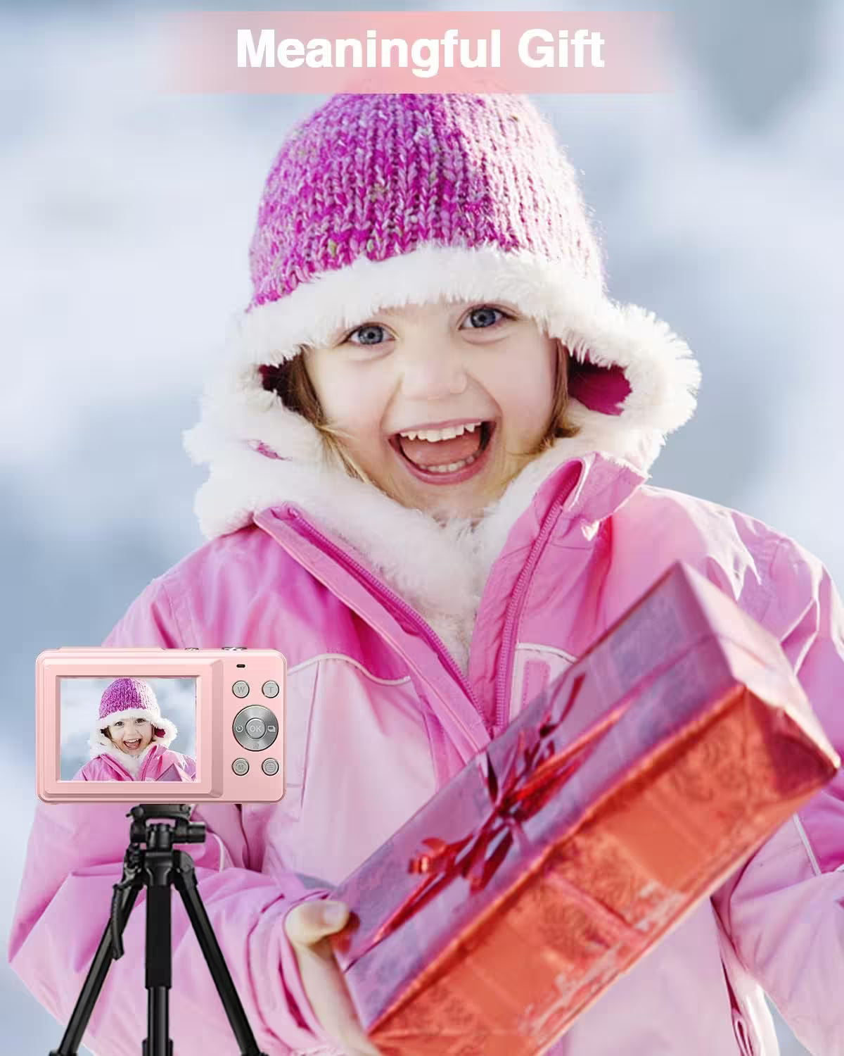 Child in pink winter coat and hat holding a gift, with a camera showing a video of themselves.