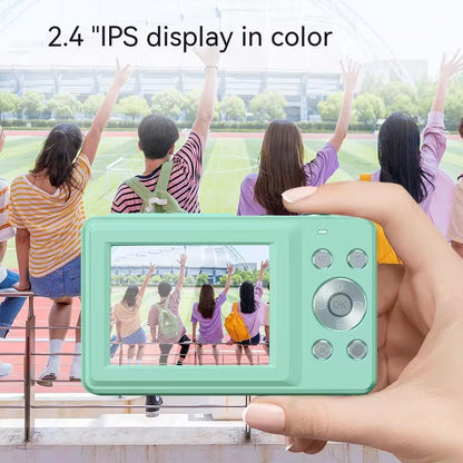 Hand holding a green digital camera with a 2.4-inch IPS display, showing a photo of people on the screen.