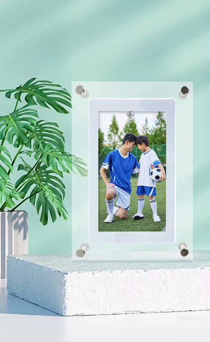 Glass photo frame with a picture of two children playing soccer on a light green background.