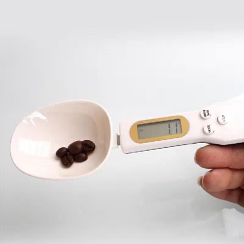 Digital kitchen scale with a bowl of chocolate chips on a white background