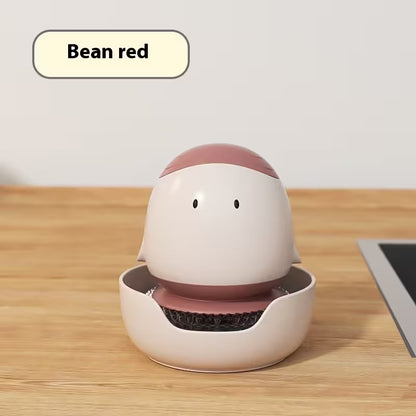 White and pink robot-like device on a wooden surface with 'Bean red' label.