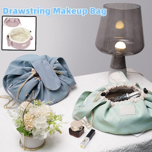 Drawstring makeup bag with cosmetic items on a table with a lamp and flowers.