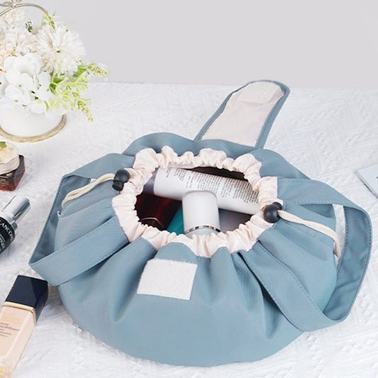 Blue fabric storage bag with cosmetic items on a white surface