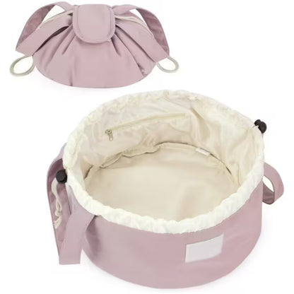Pink pet bed with white interior and drawstring top on a white background