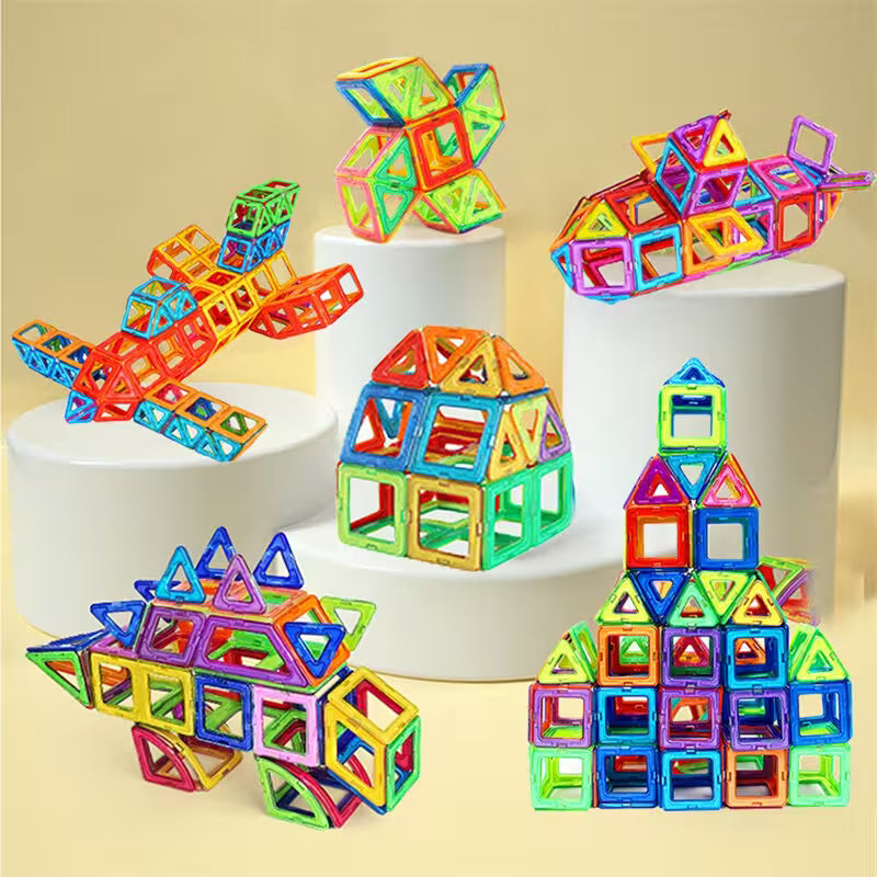 Colorful magnetic building blocks on white cylindrical stands against a beige background