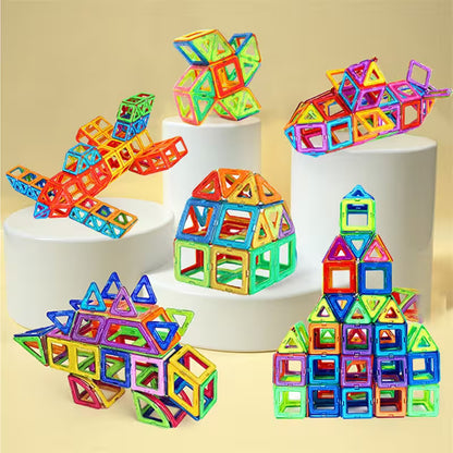 Colorful magnetic building blocks on white cylindrical stands against a beige background