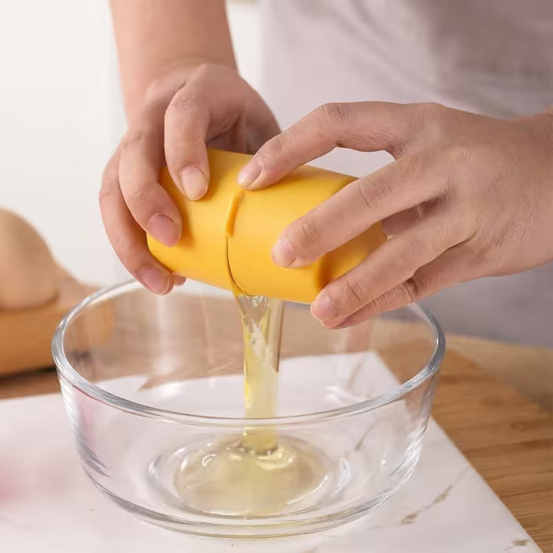 Person using a yellow lemon squeezer to extract juice into a clear glass bowl.