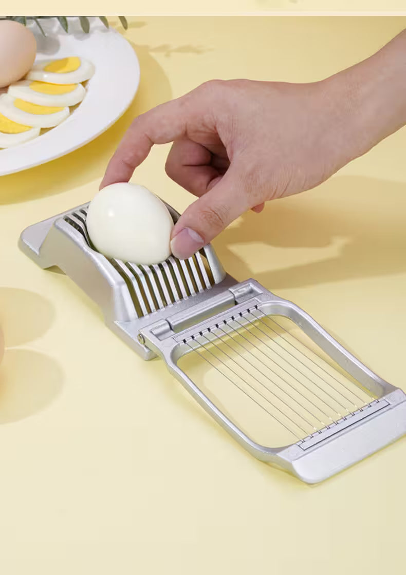 Person using an egg slicer on a yellow background