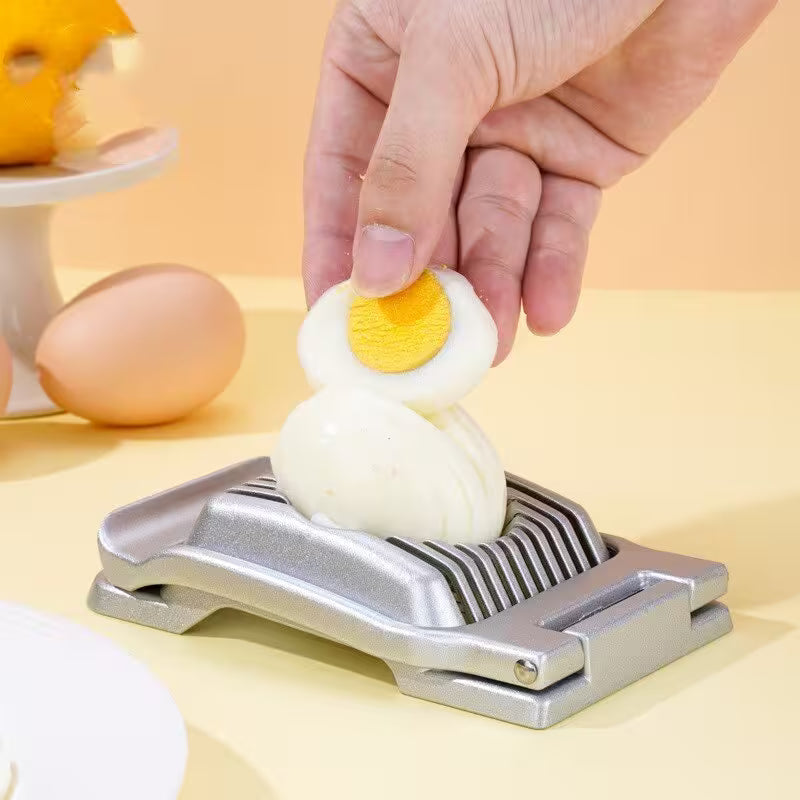 Egg being sliced with a metal egg slicer on a light background