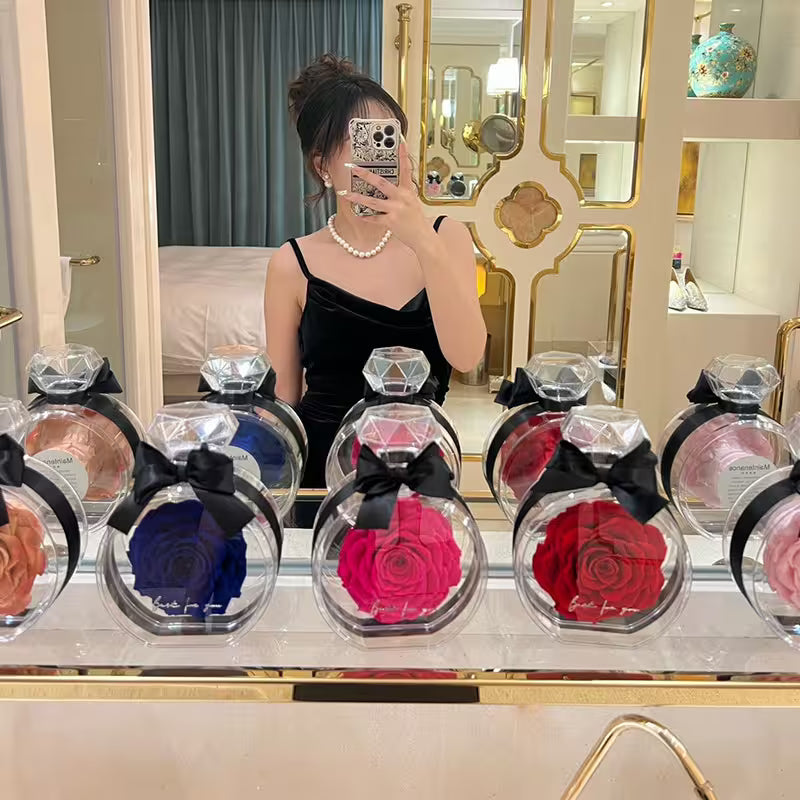 Person taking a mirror selfie with a display of colorful rose bouquets in glass spheres.