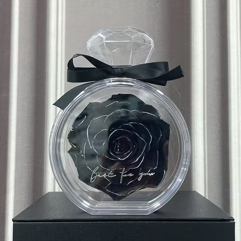 Black rose in a clear container with a diamond-shaped lid on a gray background