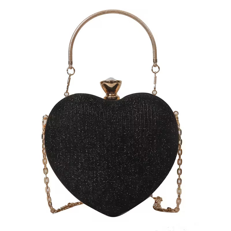 Black heart-shaped clutch bag with gold chain handle on a white background