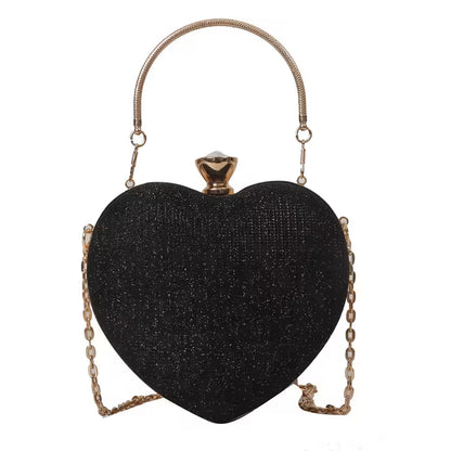 Black heart-shaped clutch bag with gold chain handle on a white background