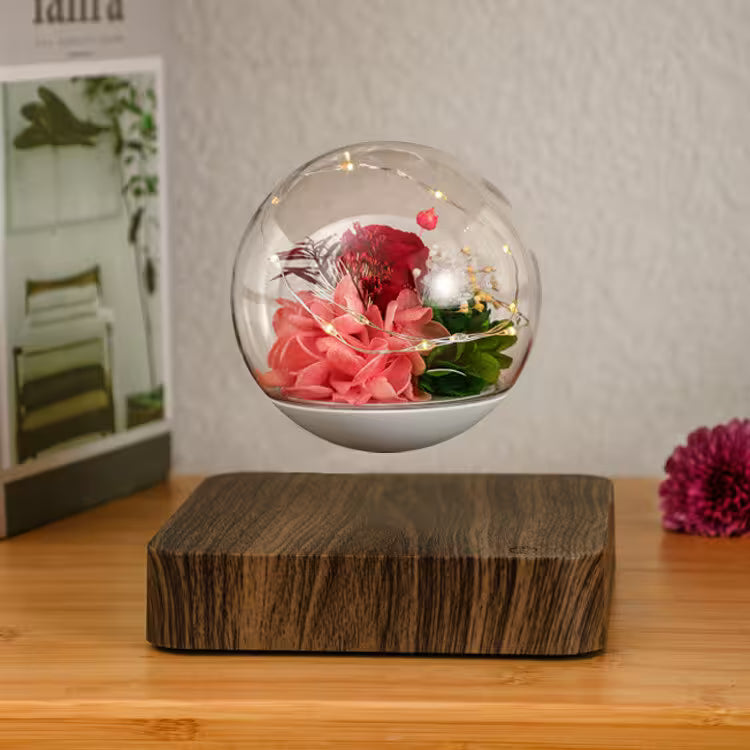 Glass orb with flowers on a wooden base against a neutral background