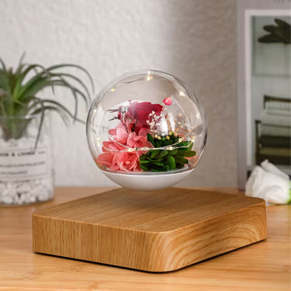 Floating glass orb with flowers on a wooden base in a room setting