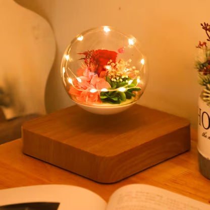 Decorative glass sphere with flowers and lights on a wooden base