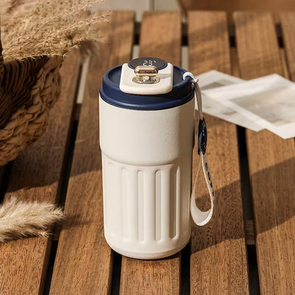 White travel mug with blue lid on a wooden surface